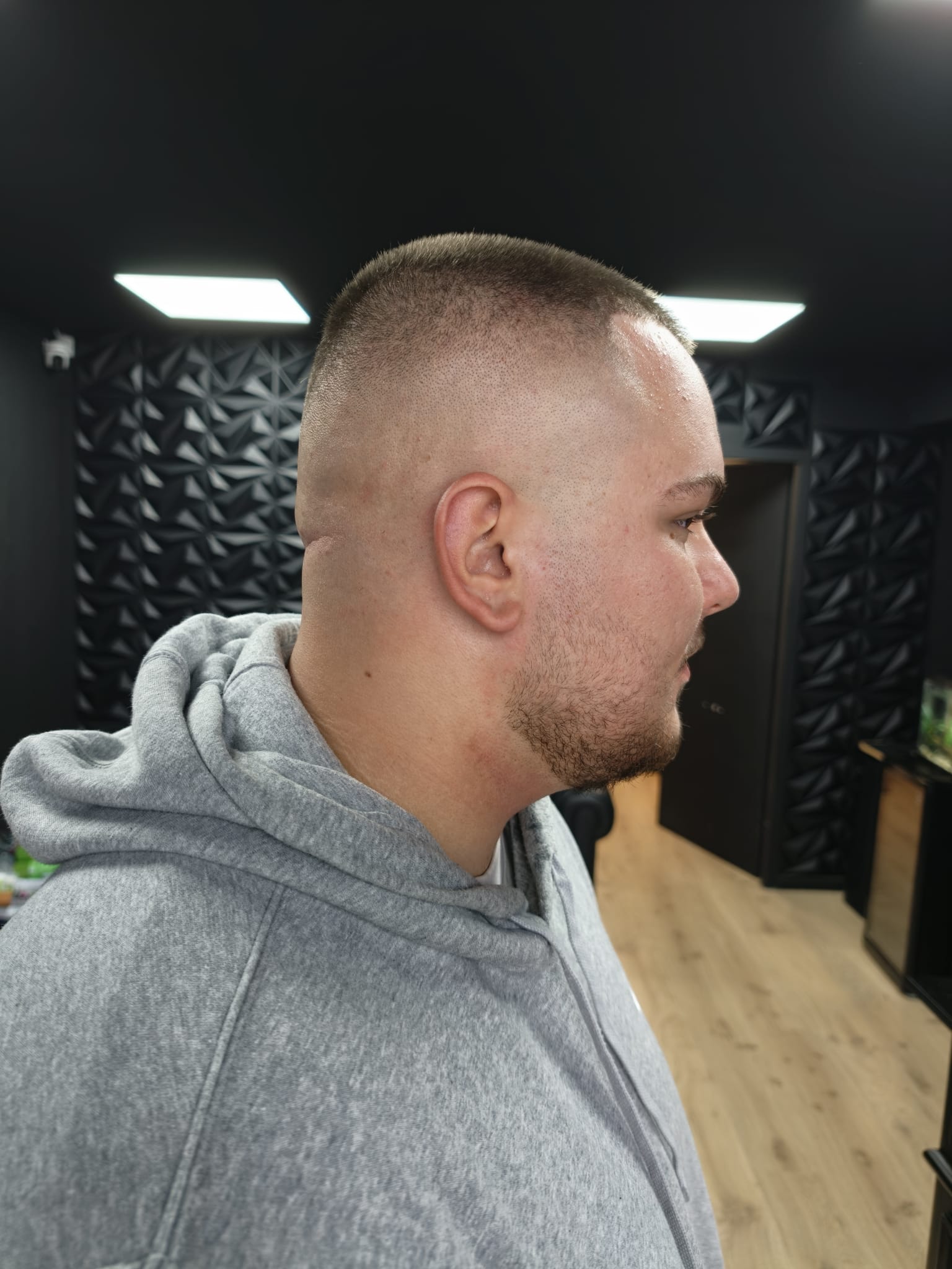 Korte fade, van opzij gezien, voor de zwarte wand in de salon