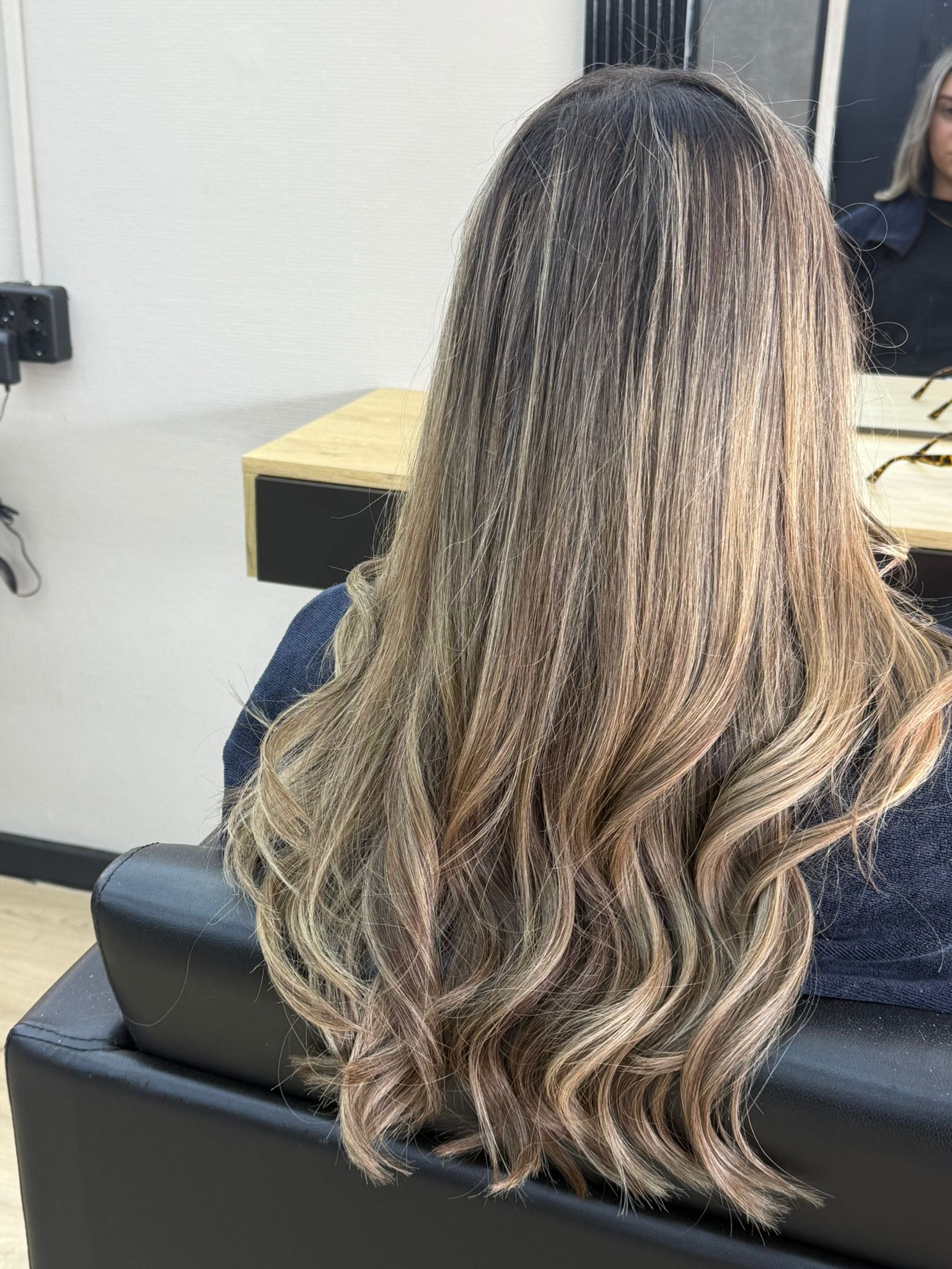 Lang haar met blonde highlights in zachte golven, van achteren gezien